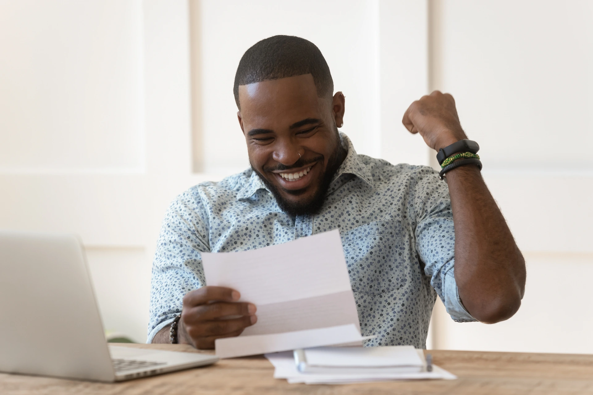 A young man excitedly reading a letter